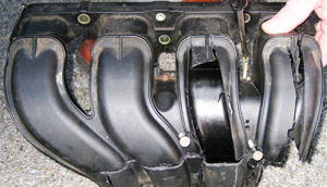 Early plastic intake manifolds such as this one for a 1990s inline 4-cylinder were often under-engineered and prone to failure because they could not handle under hood heat and pressure. External cracks, warping, and internal decay from dirty coolant were common results.) 