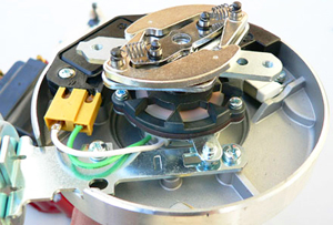 After distributor cap has been removed, this picture allows a look at a more modern type of distributor with a capacitor and computer controls for spark advance.