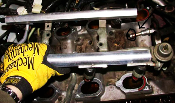 (Caption for above photo: To access fuel injectors for removal and replacement, disconnect the main fuel line (circled), unbolt the fuel rails, then pull the rails gently upward.
