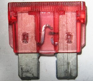 This photo shows a blade style fuse that has blown and no longer functions. Notice the conductive metal strip is broken in the middle.