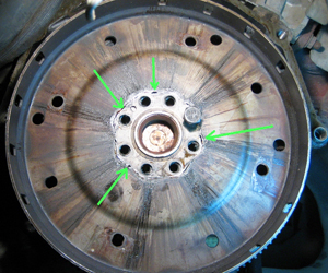 Cracks anywhere on the flywheel surface pose a risk of the entire flywheel coming apart and damaging transmission internals. Replace it with a new one.